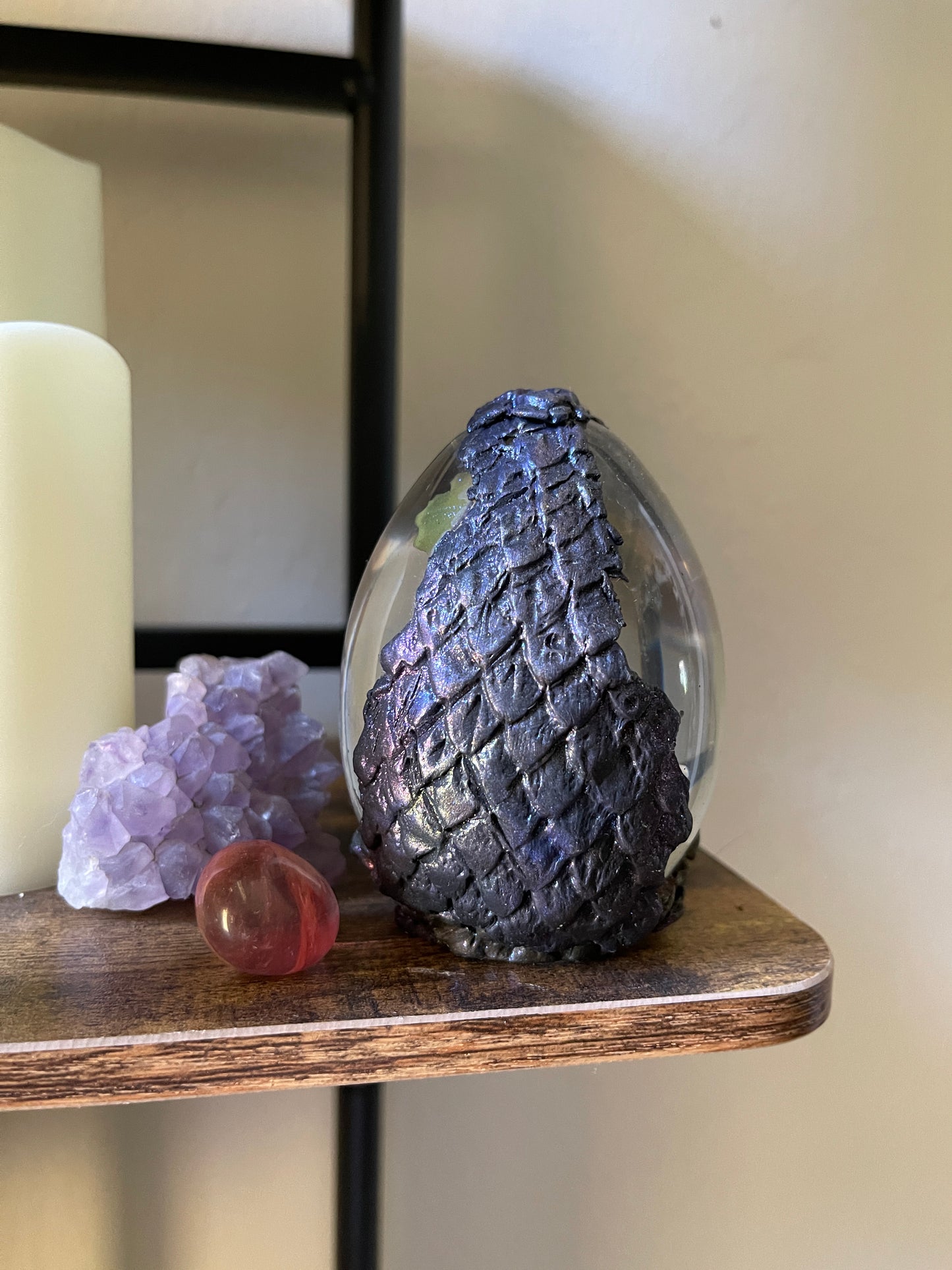 Decorative items including a textured blue object, a pink sphere, and a purple crystal on a wooden shelf.