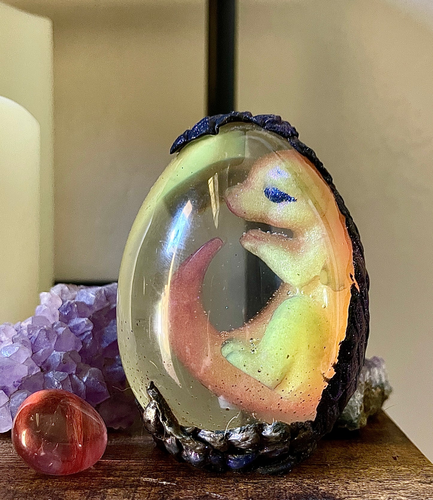 Decorative item with a small animal figure inside a glass sphere on a wooden surface.