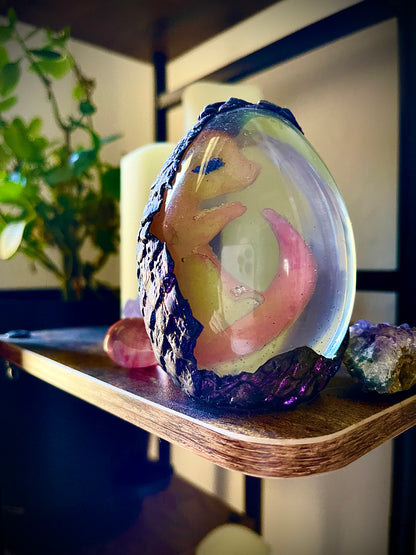 Decorative glass sphere with a figurine on a wooden shelf