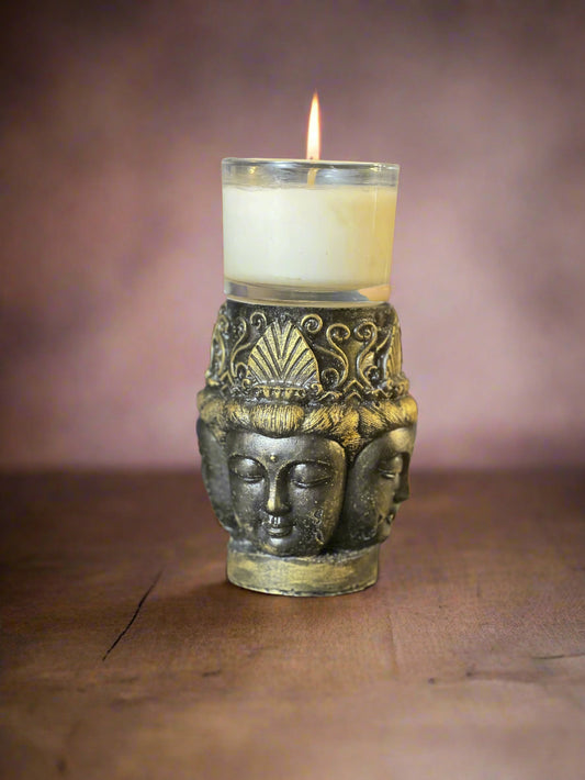 Decorative candle holder with a face design on a dark surface
