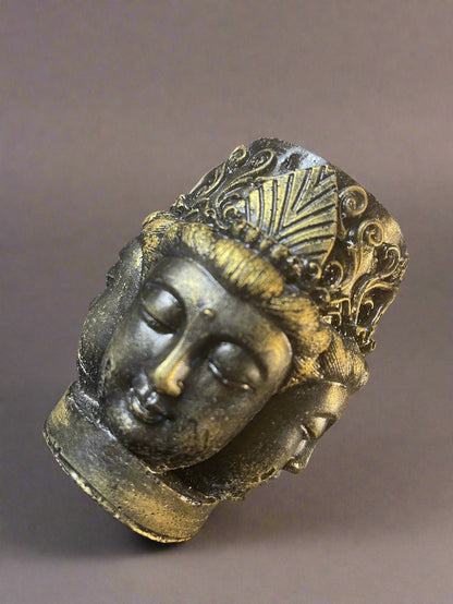 Decorative buddha head with intricate designs on a reflective surface