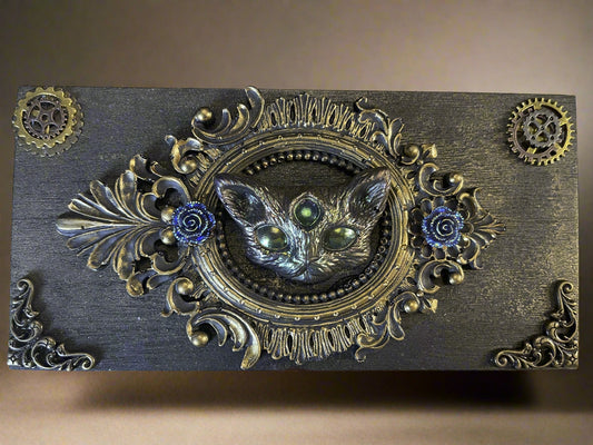 Decorative box with a cat's face and floral elements on a textured background